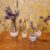 Set of 4 Mini Bottle/Bud Vases, with hand embroidered floral felt bands in lilac, pink and blues.